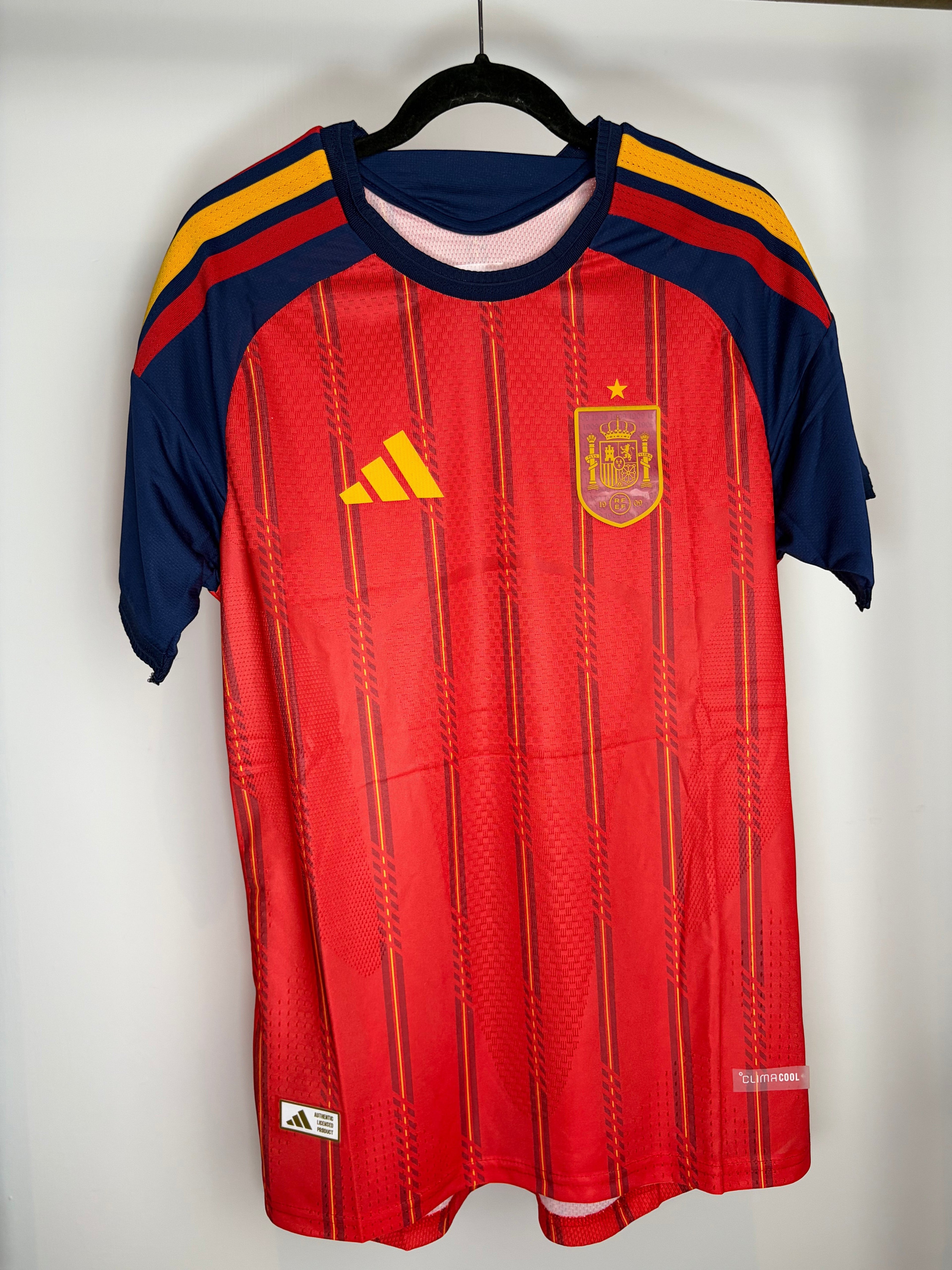 Camiseta oficial de España Local My Store 3 roja con detalles en azul y amarillo, escudo con holograma y Climacool.